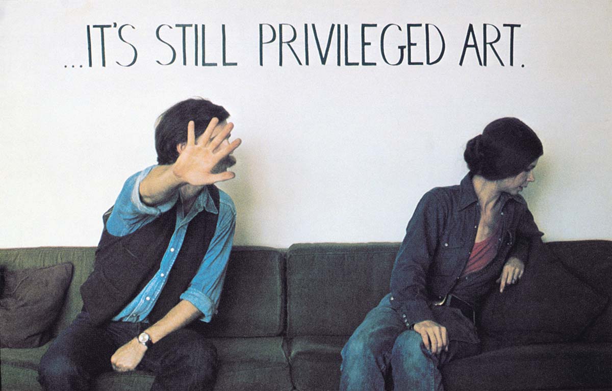 A man and a woman sit on a sofa, turning away from the camera, with “… It’s still privileged art” written above them. 