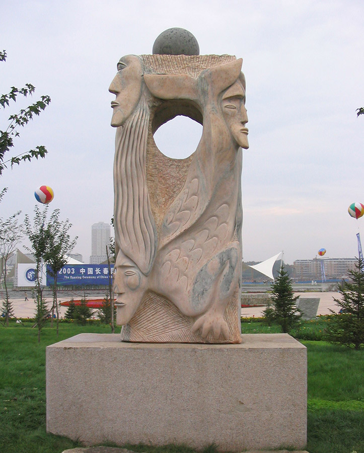A pink marble sculpture of three characters on display in a public park. 