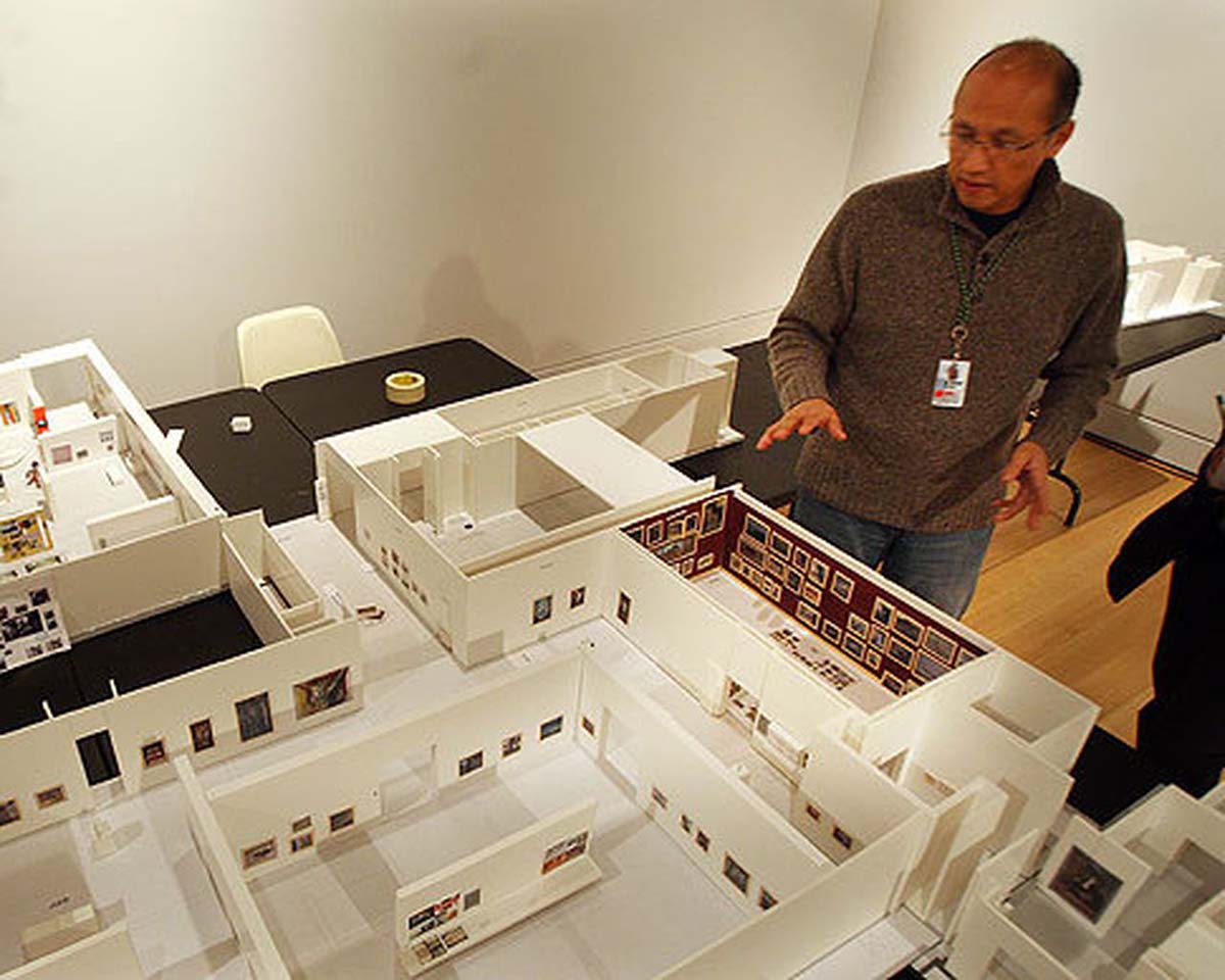 A man standing near exhibition hall models. 