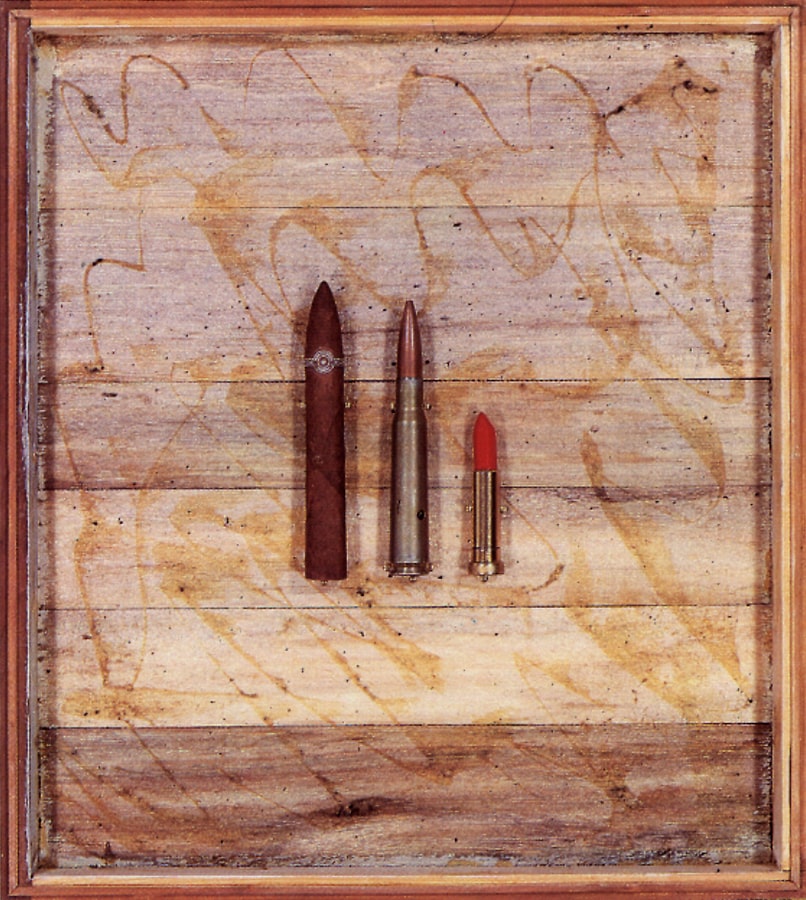 A wooden box with a cigar, a bullet and a lipstick inside. 