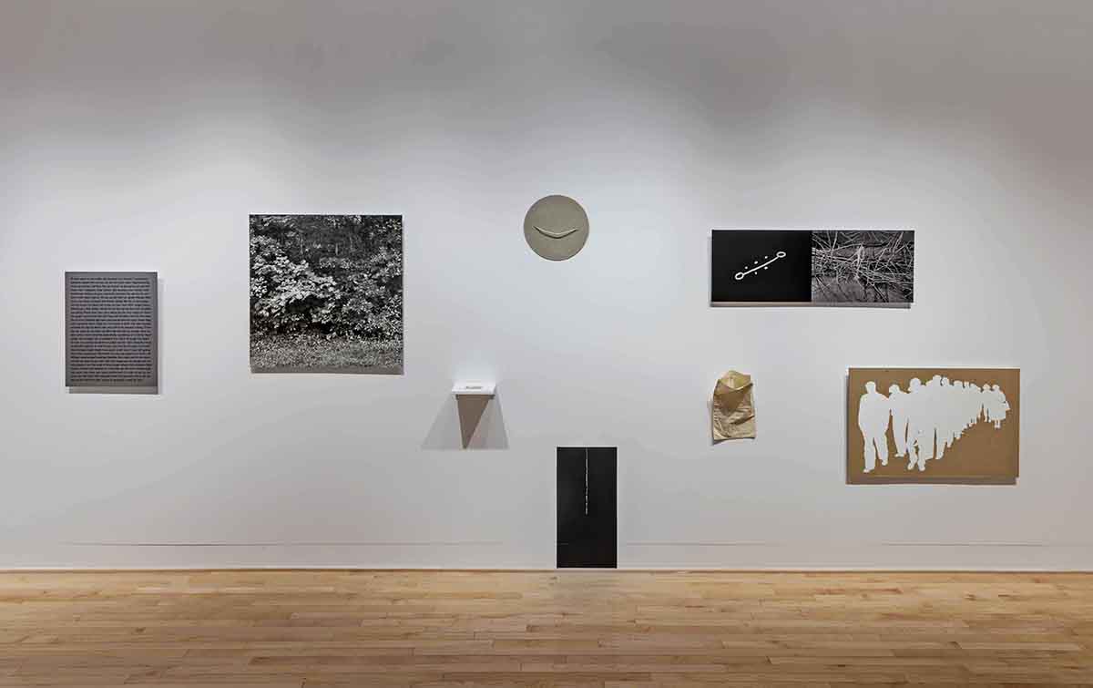 Various pieces of artwork displayed on a white gallery wall. 