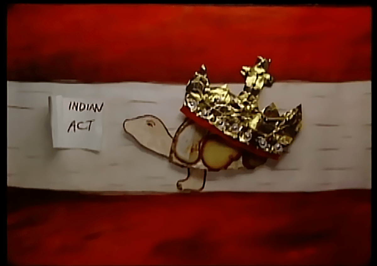 A piece of bark, a wooden turtle and a piece of gold next to a paper that reads “Indian Act.”  